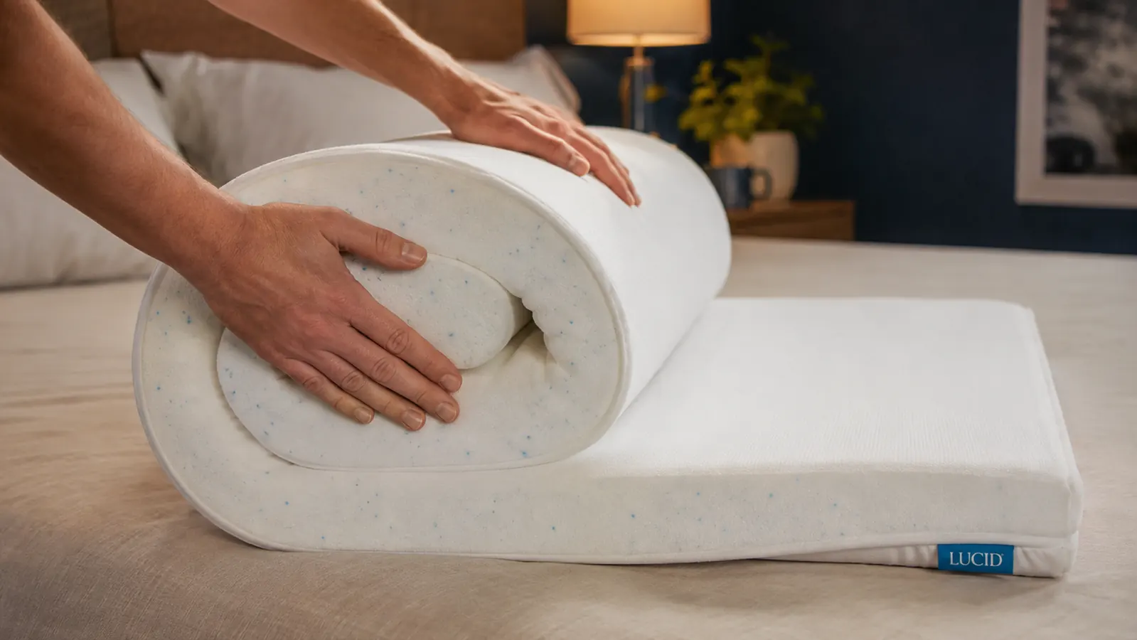 Close-up of a blue gel-infused memory foam mattress topper being unrolled onto a mattress